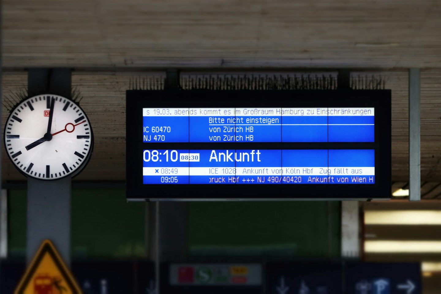 Togstasjonklokken viser 08:08 ved siden av digital avgangstavle.